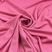 Pink ponte de roma fabric pulled into a swirl to show off structure and drape