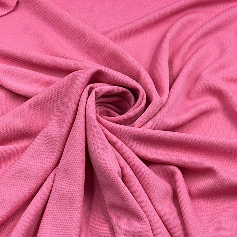 Pink ponte de roma fabric pulled into a swirl to show off structure and drape