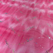 Pink fabric with a cloudy, marbled texture and scattered multicolored sequins and glitter.