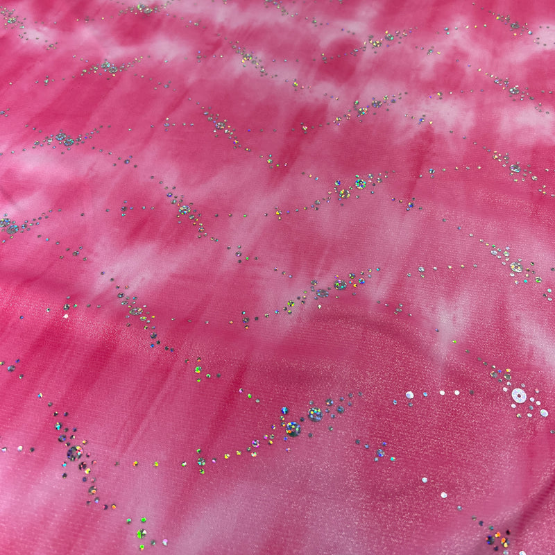 Pink fabric with a cloudy, marbled texture and scattered multicolored sequins and glitter.