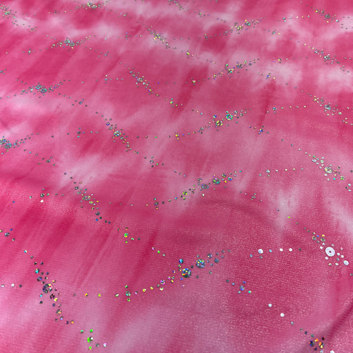 Pink fabric with a cloudy, marbled texture and scattered multicolored sequins and glitter.