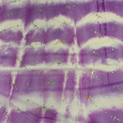 Purple and white tie-dye fabric with scattered iridescent glitter.