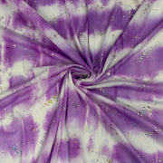 Purple and white tie-dye fabric with scattered iridescent glitter, arranged in a spiral drape pattern.