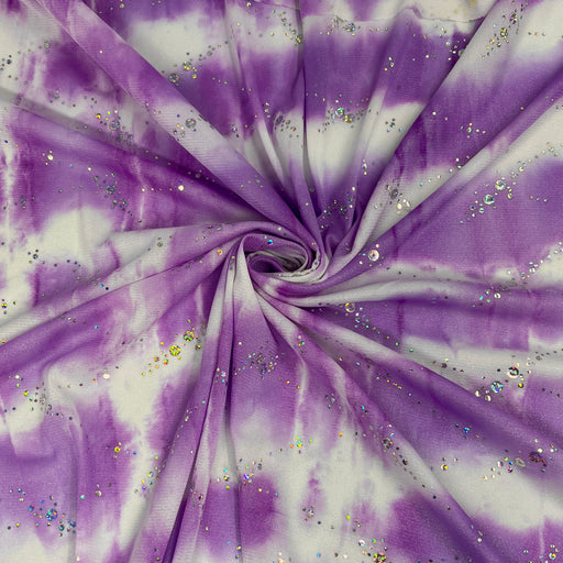 Purple and white tie-dye fabric with scattered iridescent glitter, arranged in a spiral drape pattern.