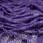 Purple eyelet lace fabric with a shimmering metallic texture, draped to show its openwork pattern and texture.
