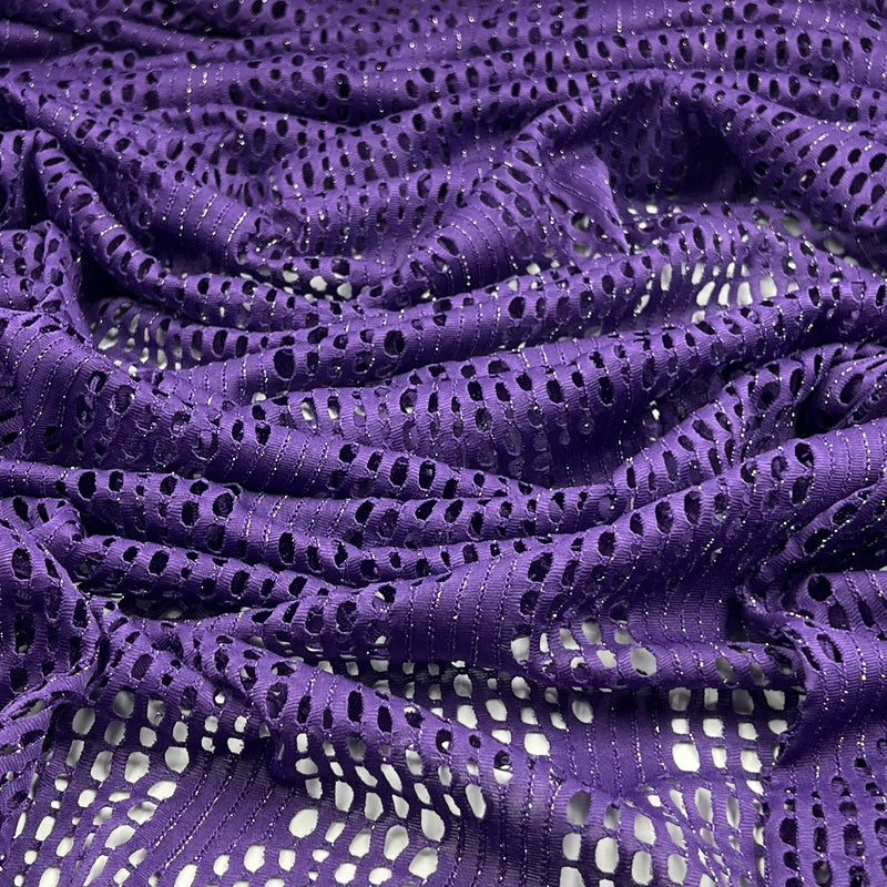 Purple eyelet lace fabric with a shimmering metallic texture, draped to show its openwork pattern and texture.
