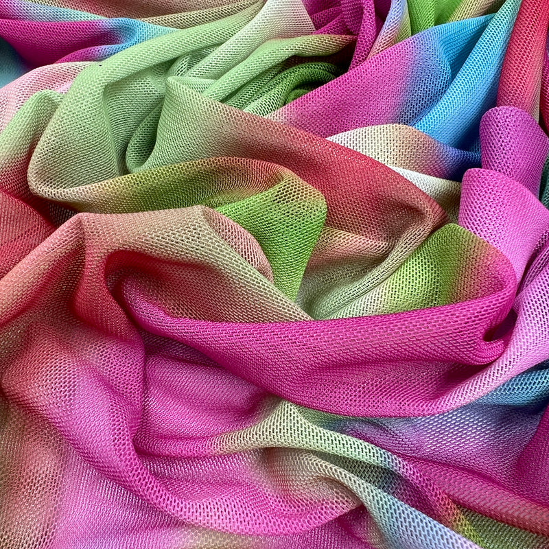 A close-up of draped mesh fabric with a soft rainbow gradient transitioning through pink, green, yellow, blue, and purple.