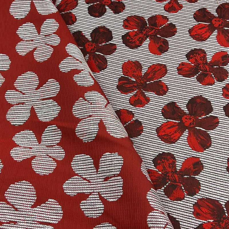 Two close-up views of a patterned fabric. One side shows a deep red background with large white floral motifs, and the other shows a light gray striped background with smaller red floral motifs.