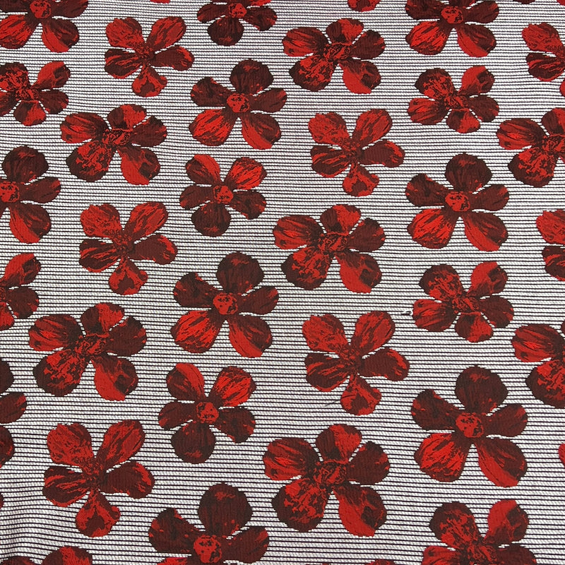 A close-up of a woven fabric featuring a repeating pattern of red and dark red floral motifs on a gray and white striped background.
