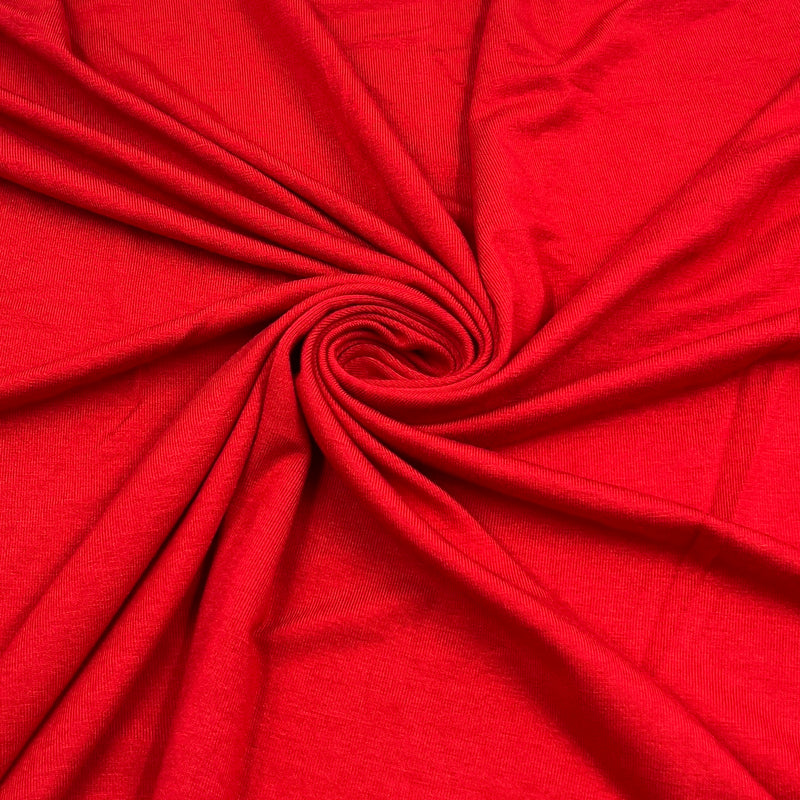 Bright red fabric draped in a spiral pattern, showing its texture and color.