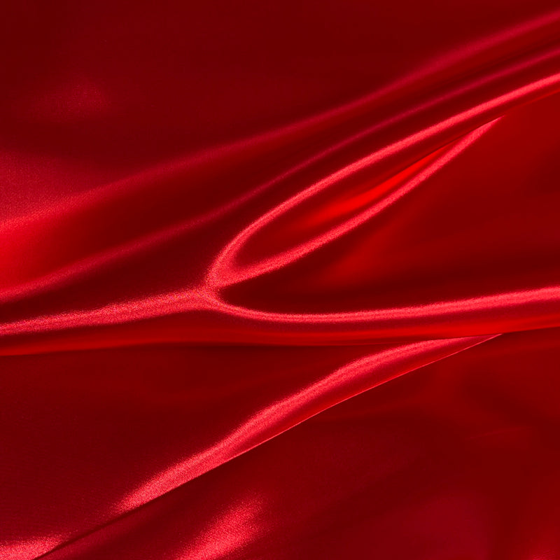 Red satin fabric with elegant folds and a glossy sheen, filling the entire frame.