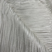 A close-up of a textured silver fabric with a raised, wavy chevron pattern.