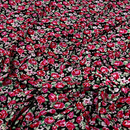 Black fabric with an all-over dense floral print featuring red, pink, and white flowers with green leaves.