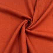Rust orange laundered linen pulled into a swirl to show off smooth drape. 