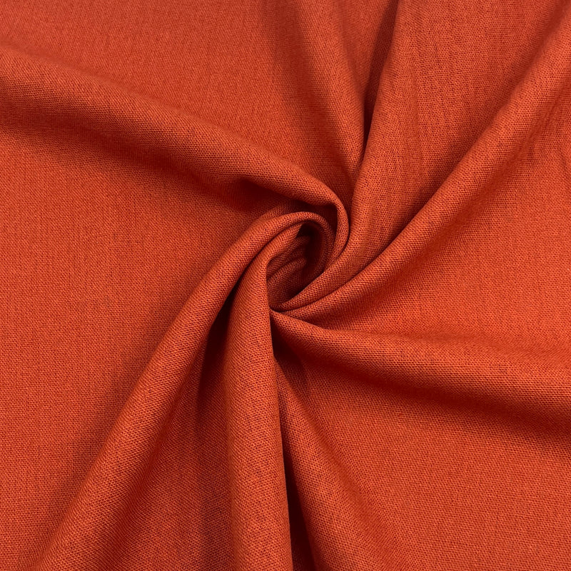 Rust orange laundered linen pulled into a swirl to show off smooth drape. 