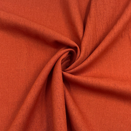 Rust orange laundered linen pulled into a swirl to show off smooth drape. 