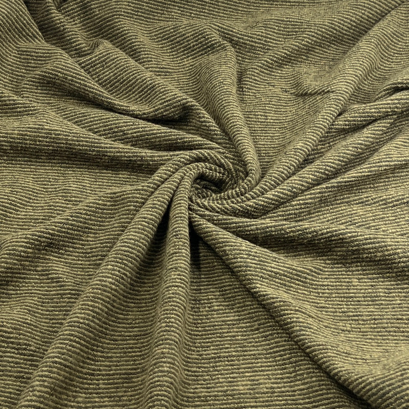 A close-up of olive green ribbed fabric, gathered in the center to show its texture and drape.