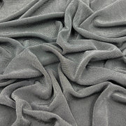 A close-up of draped gray fabric with a fine ribbed or waffle-like texture, filling the entire frame.