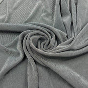 A close-up of draped gray fabric arranged in a spiral, showing the material texture and color.