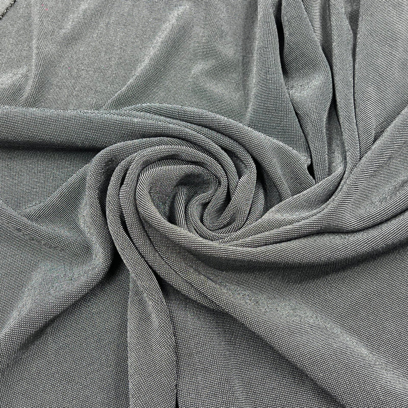 A close-up of draped gray fabric arranged in a spiral, showing the material texture and color.