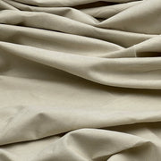 A close-up of draped beige fabric with soft folds and a fine woven texture.