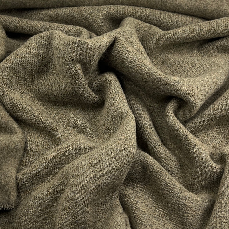 A close-up of draped olive green knit fabric with a soft, textured weave.