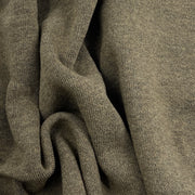 A close-up of draped knit fabric in a muted taupe-gray color, showing the texture and weave detail.