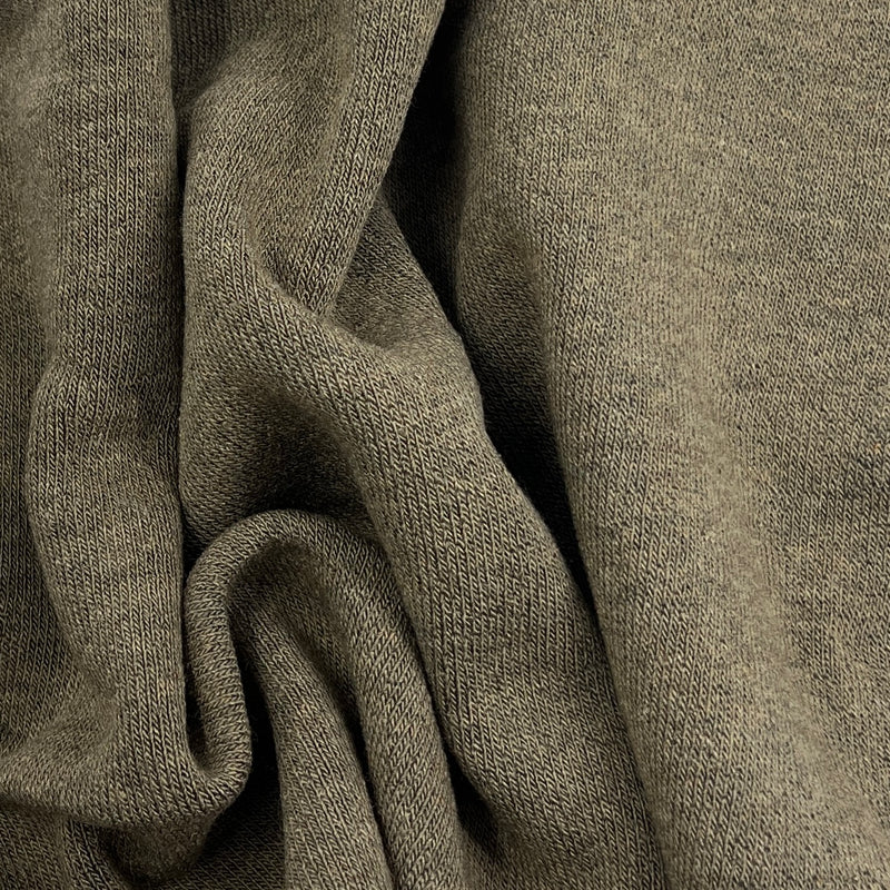A close-up of draped knit fabric in a muted taupe-gray color, showing the texture and weave detail.
