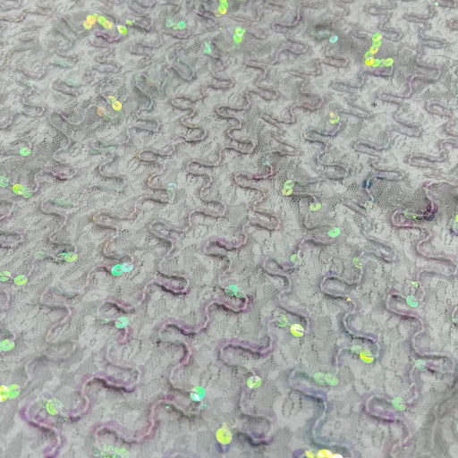 Close-up of a gray textured fabric with raised wavy patterns and scattered iridescent sequins.