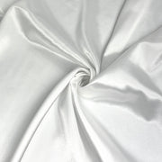 A close-up of draped white satin fabric with a central swirl, showing its smooth texture and soft sheen.