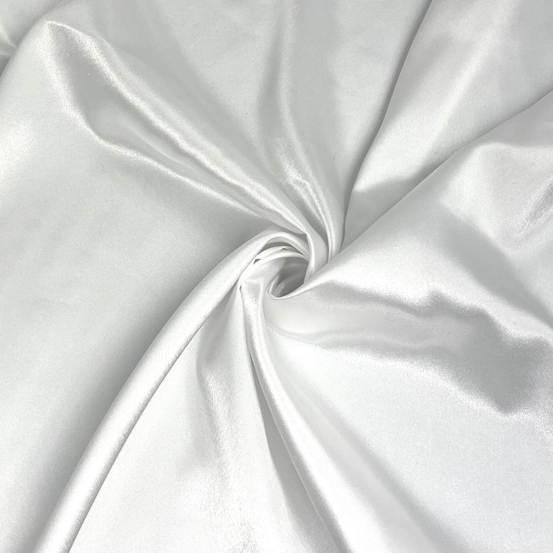 A close-up of draped white satin fabric with a central swirl, showing its smooth texture and soft sheen.