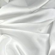 White satin fabric with a smooth, lustrous texture and soft draped folds.
