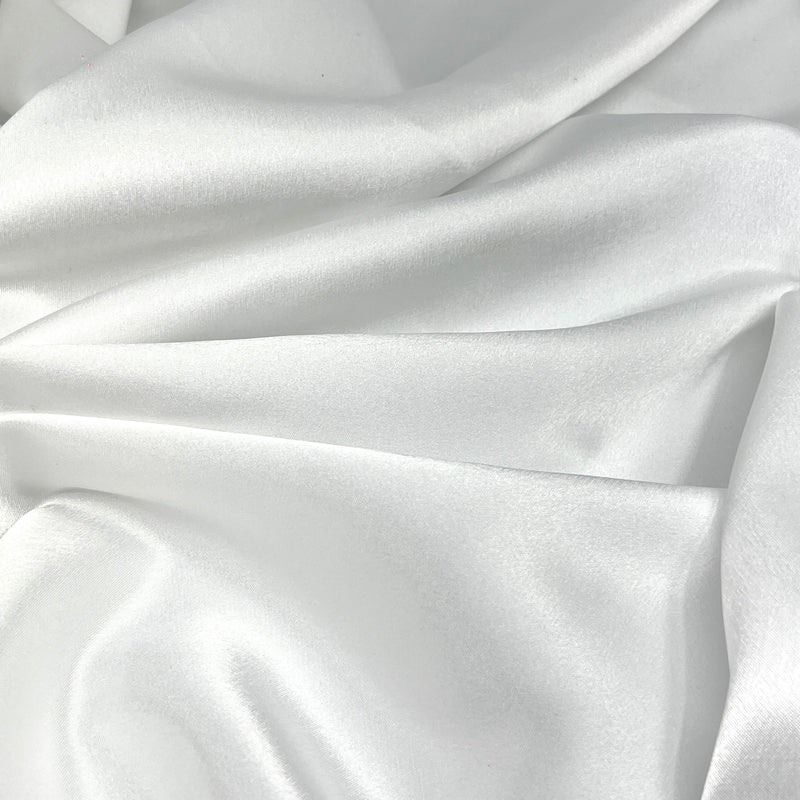 White satin fabric with a smooth, lustrous texture and soft draped folds.