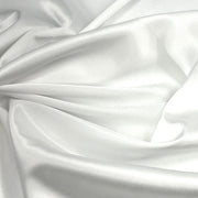 White satin fabric draped in soft folds, showing a smooth, lustrous texture with a subtle sheen.
