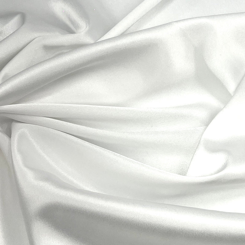 White satin fabric draped in soft folds, showing a smooth, lustrous texture with a subtle sheen.