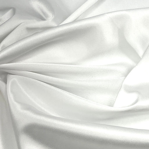 White satin fabric draped in soft folds, showing a smooth, lustrous texture with a subtle sheen.