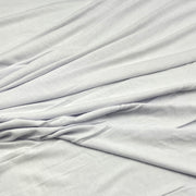 White fabric with soft folds and a smooth texture, filling the entire frame.