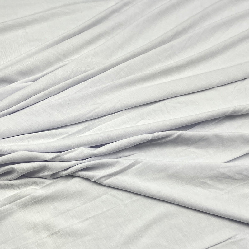 White fabric with soft folds and a smooth texture, filling the entire frame.