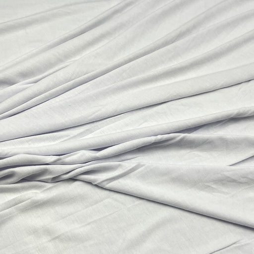 White fabric with soft folds and a smooth texture, filling the entire frame.