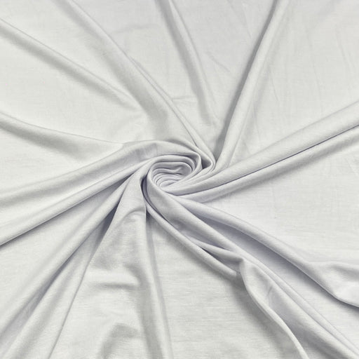 White fabric draped in a spiral pattern to show its soft texture and drape.