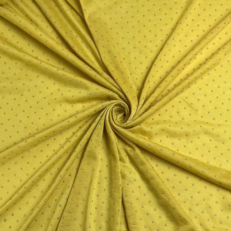 Yellow fabric with a small repeating silver dot pattern, draped in a spiral swirl to show texture and drape.