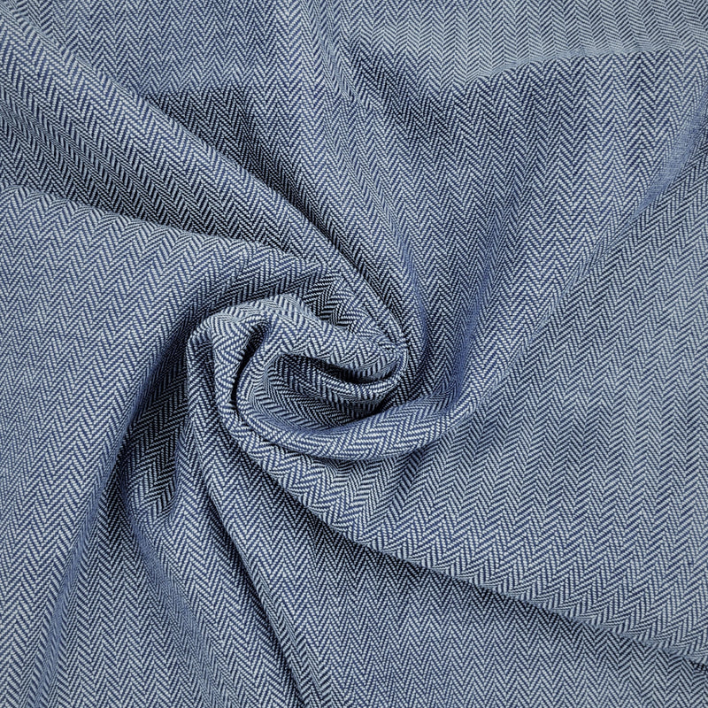 Close-up of blue and white cotton herringbone shirting fabric with a visible pattern