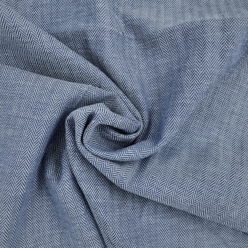 Close-up of blue and white cotton herringbone shirting fabric with a visible pattern